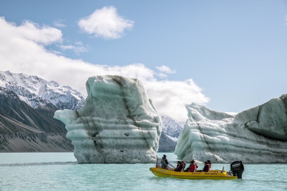 Glacier Explorer boat cruising past an iceberg at Mount Cook
