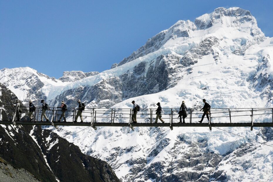 Hikers crossing a bridge on the Hooker Valley Track