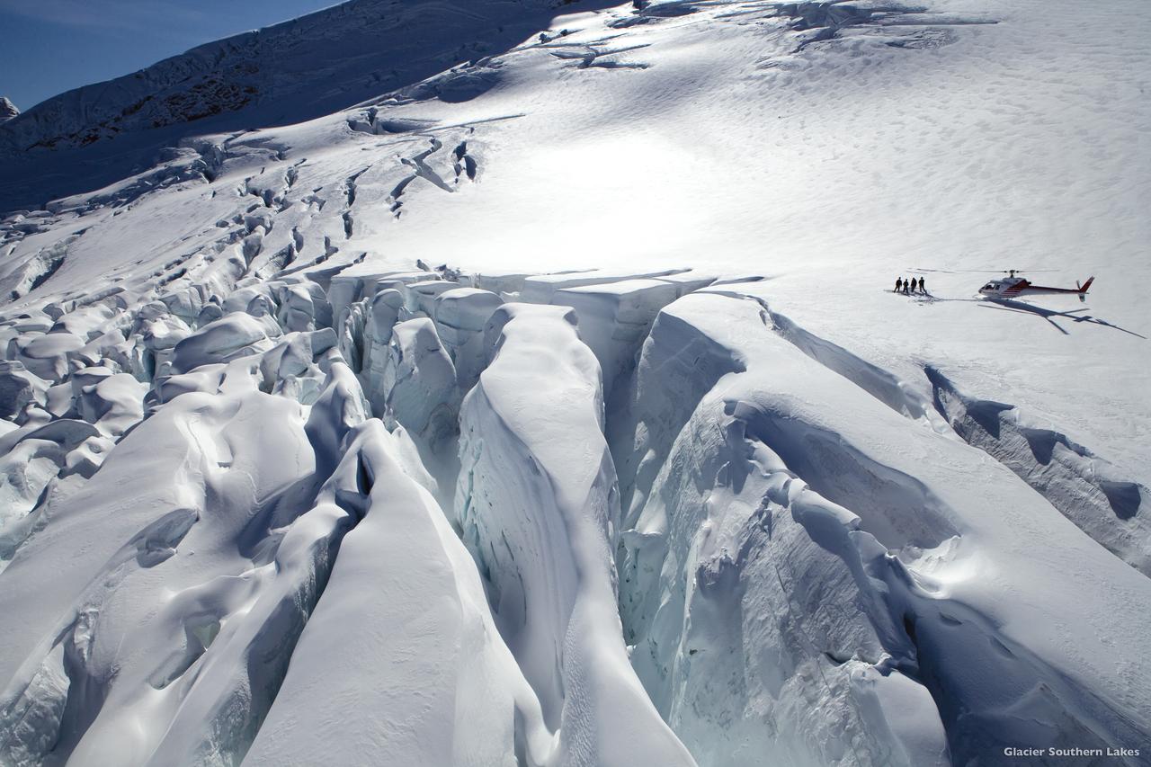 Aerial view of helicopter and people on glacier