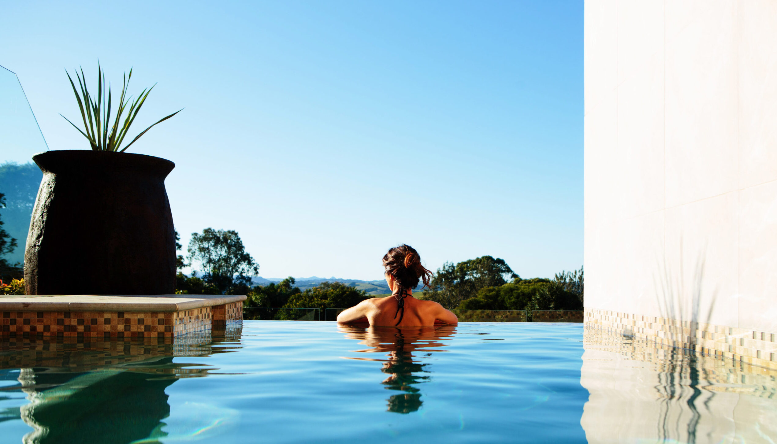 Woman looking at scenery from infinity pool at Gaia Retreat