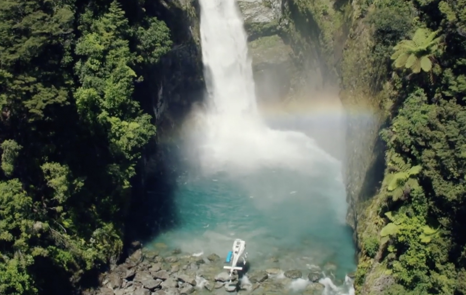 Helicopter at the foot of waterfall New Zealand private luxury tour